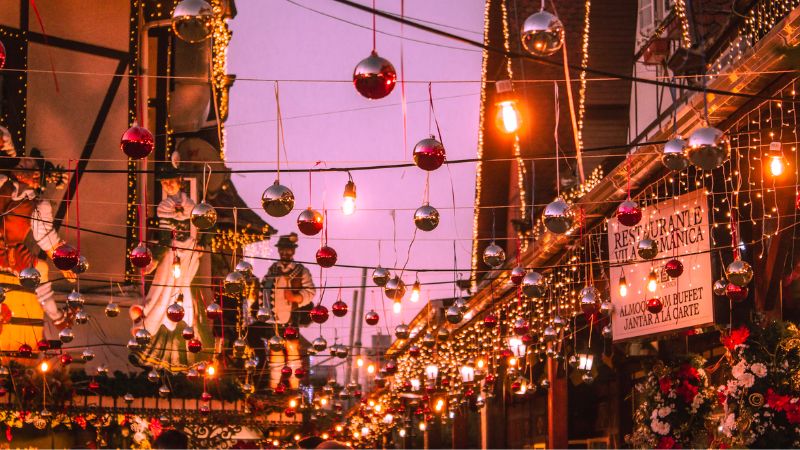 Natal a noite com luzes douradas e decorações natalinas vermelhas e cinzas