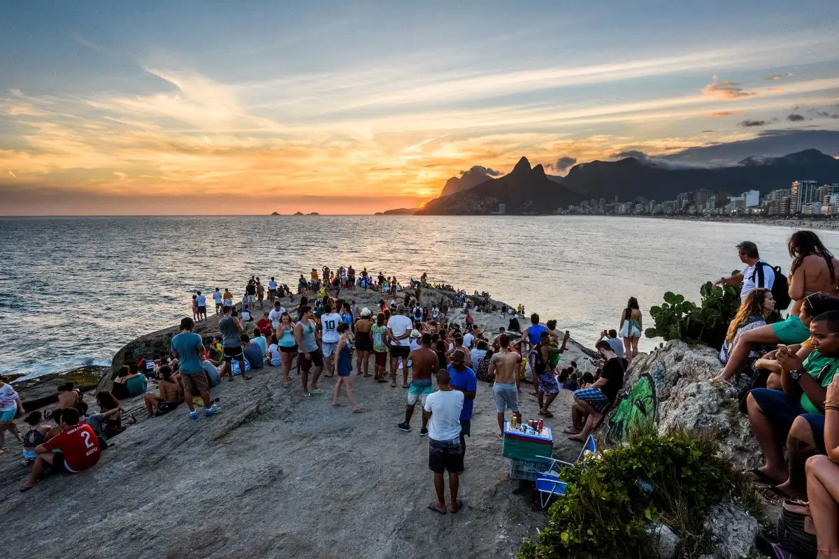 pessoas assistindo o por do sol na pedra do arpoador rj