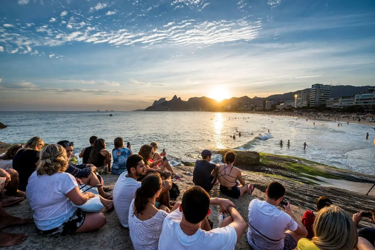 pessoas assistindo o por do sol na pedra do arpoador rj